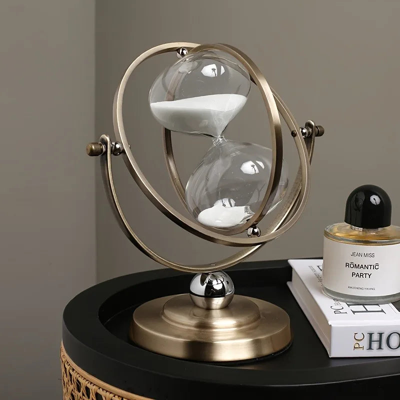 Vintage hourglass 30-minute sand timer on brass pedestal with circular frame, antique desk clock.